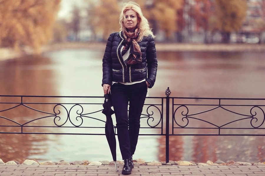 Eine Frau steht mit dem Rücken an einem Brückengeländer gelehnt